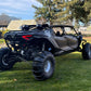 Black maverick r max in the grass with wci offroad cage and rear bumper