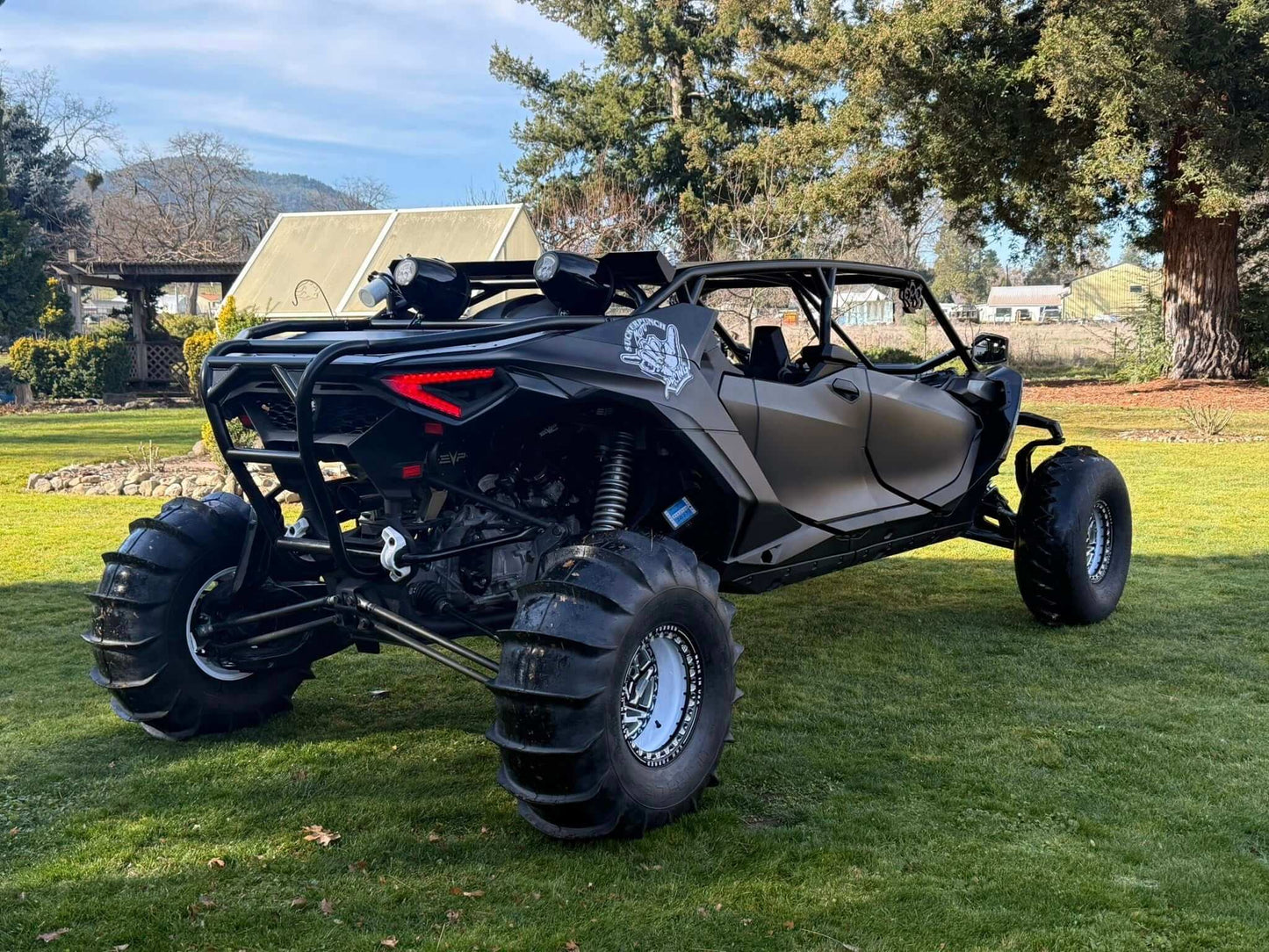 Black maverick r max in the grass with wci offroad cage and rear bumper