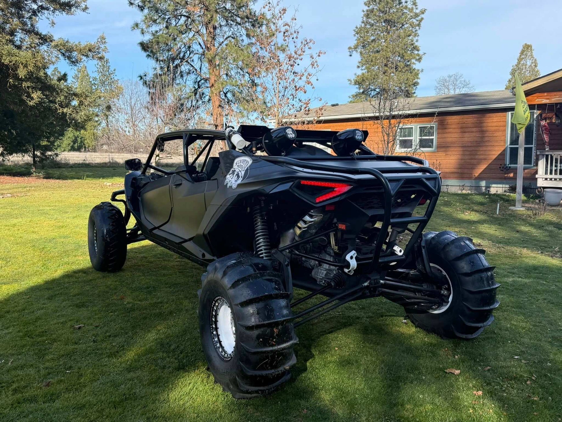 Black can-am maverick r max in the grass with wci offroad cage and rear bumper