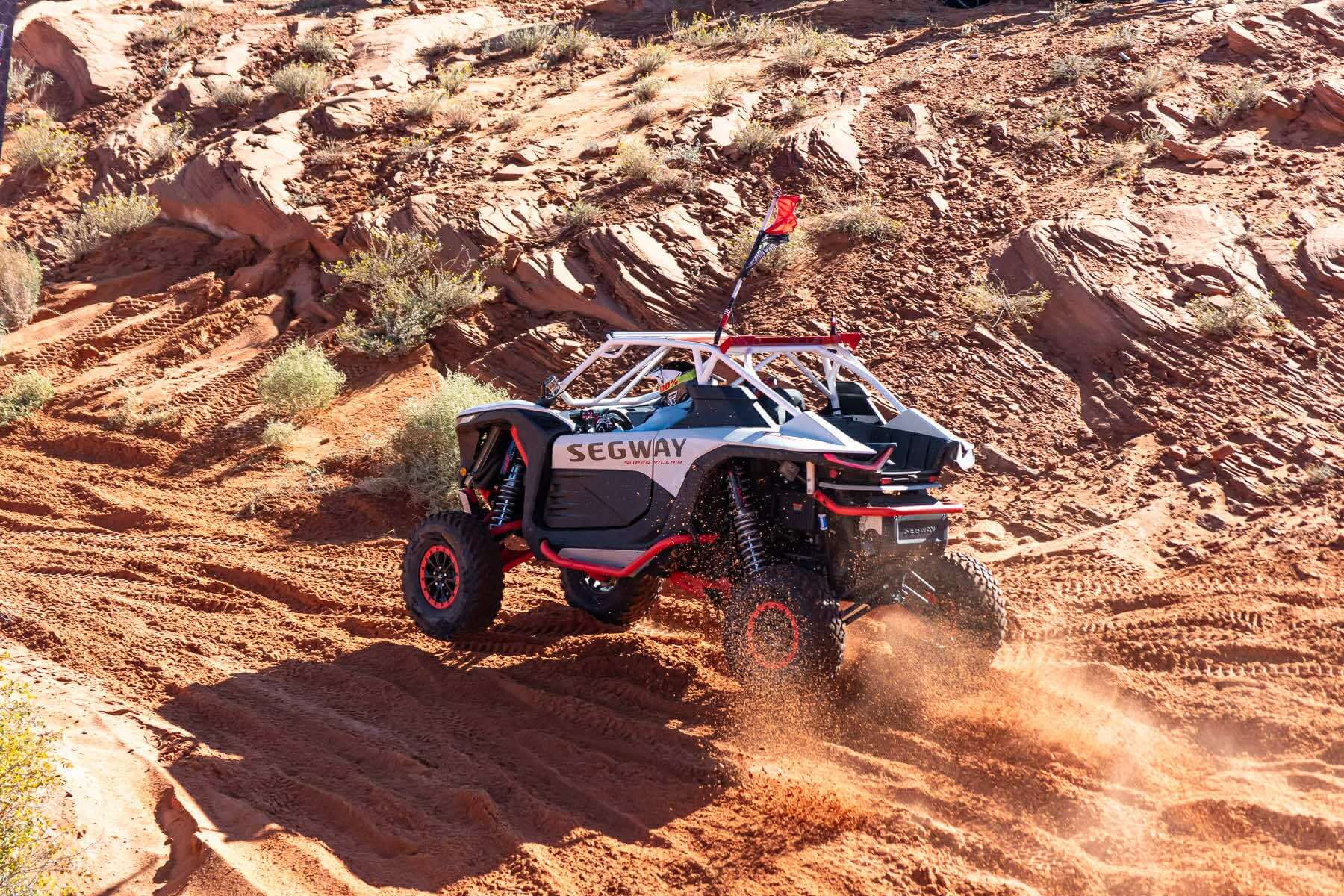 Off-road vehicle on a rocky desert trail with Segway branding, with WCI Off-road segway super villain roll cage